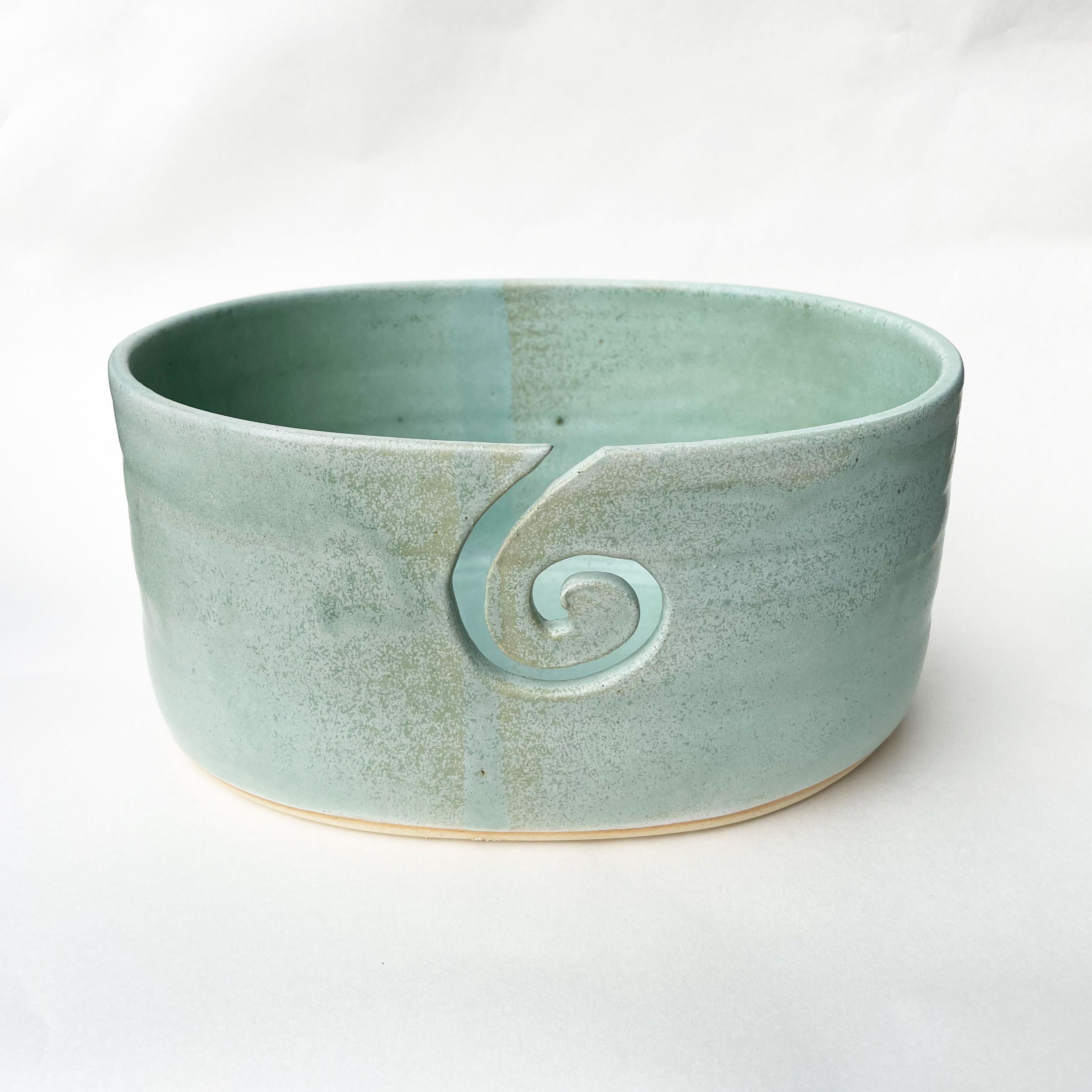 hand thrown teal yarn bowl with heart shaped cut out